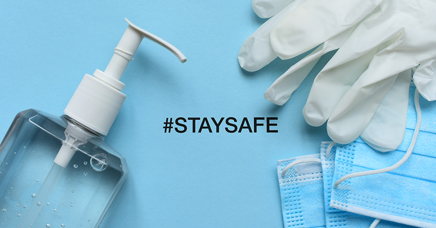 A bottle of hand sanitizer, face masks and a pair of gloves around the words that say stay safe